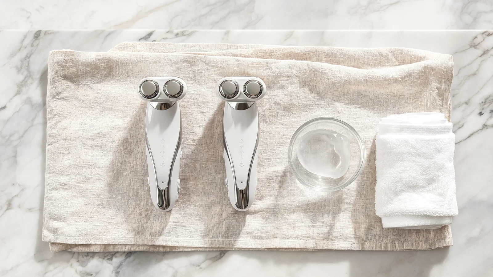 Two NuFace microcurrent facial devices side by side on linen towel